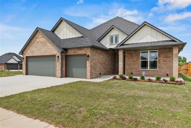 10513 SW 51st St, Mustang, OK 73064 - view of front facade featuring a garage, board and batten siding, brick siding, driveway, and roof with shingles