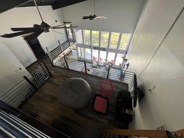 stairs with hardwood / wood-style flooring, ceiling fan, and high vaulted ceiling