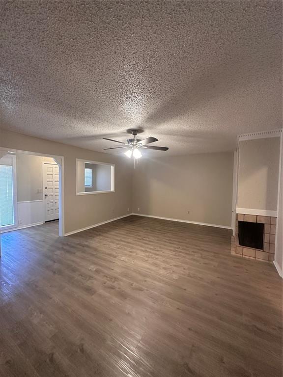 unfurnished living room featuring a textured ceiling, ceiling fan, and dark hardwood / wood-style floors