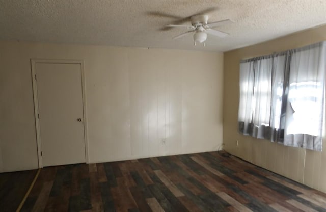 spare room featuring ceiling fan, dark hardwood / wood-style flooring, and a textured ceiling