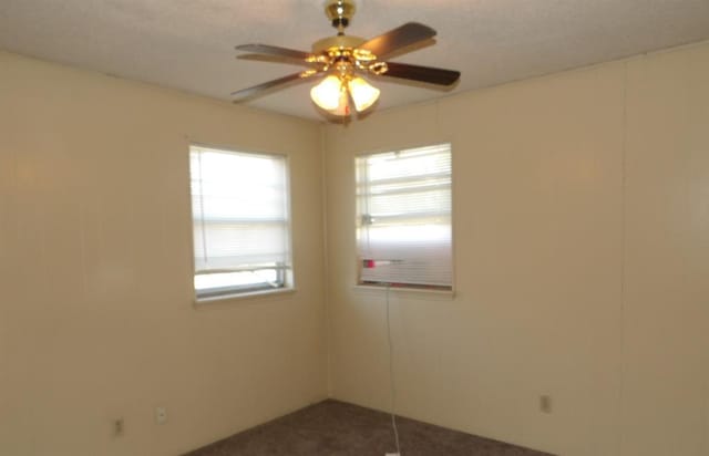 104 Gatewood Dr, Chickasha, OK 73018 - empty room with dark colored carpet and a ceiling fan