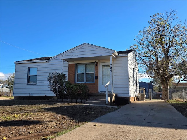 view of front of home with entry steps, driveway, central AC unit, and fence