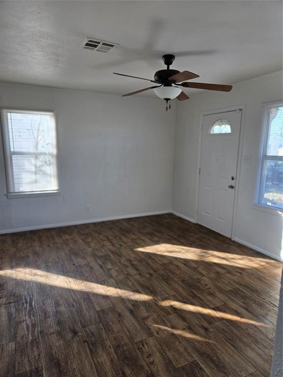 entrance foyer with dark wood-type flooring, visible vents, baseboards, and a ceiling fan