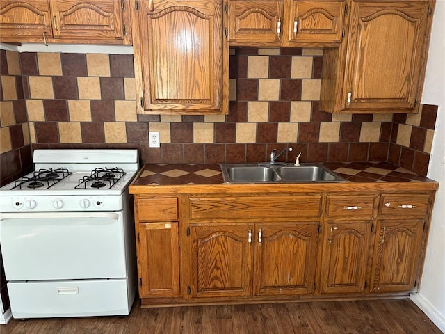 kitchen with decorative backsplash, dark wood-style flooring, white gas stove, and a sink