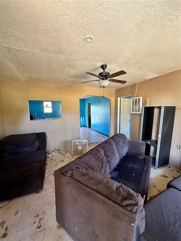 living room with a textured ceiling and ceiling fan