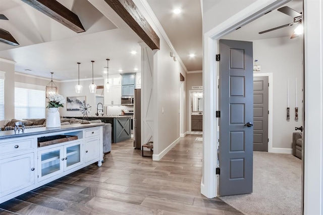 kitchen with white cabinets, ceiling fan, pendant lighting, and wood-type flooring