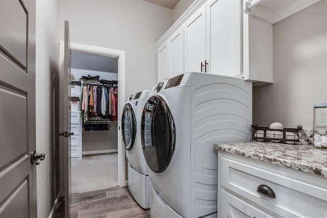 laundry room with cabinets, independent washer and dryer, and dark wood-type flooring