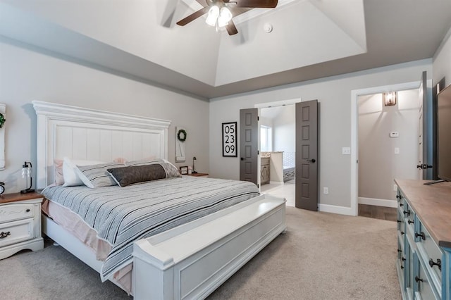 bedroom with ceiling fan, light colored carpet, connected bathroom, and vaulted ceiling