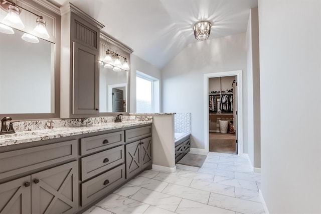 bathroom featuring a bathing tub, vanity, and lofted ceiling