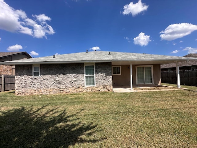 rear view of house with a lawn and a patio