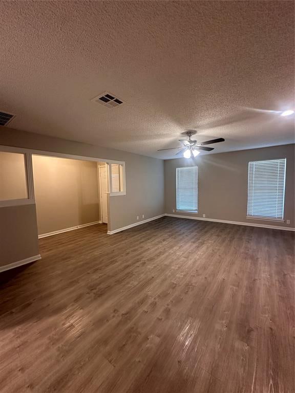 spare room with ceiling fan, dark hardwood / wood-style flooring, and a textured ceiling