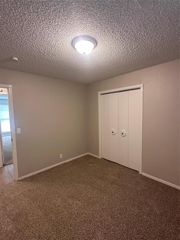 unfurnished bedroom featuring a closet, carpet floors, and a textured ceiling