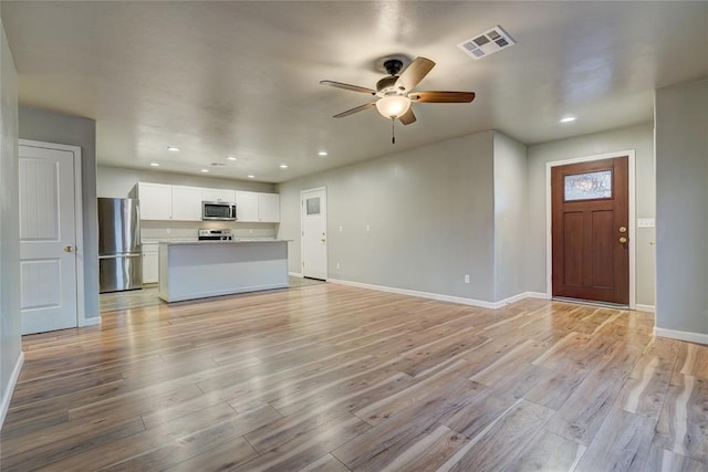 unfurnished living room with ceiling fan and light hardwood / wood-style floors