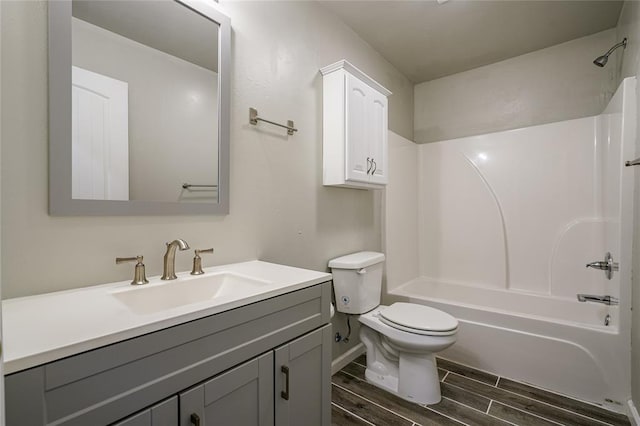 full bathroom with washtub / shower combination, vanity, wood-type flooring, and toilet