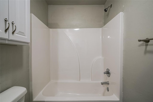 bathroom with shower / bath combination and toilet