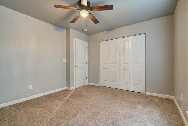 unfurnished bedroom with ceiling fan, light carpet, and a closet