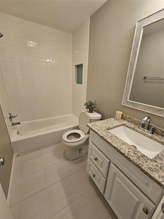 full bathroom featuring vanity, tile patterned floors, tiled shower / bath combo, and toilet