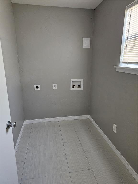 clothes washing area featuring hookup for a washing machine and hookup for an electric dryer