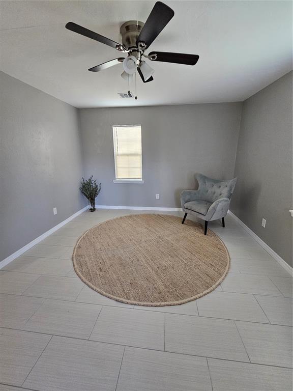 living area featuring ceiling fan and light tile patterned flooring