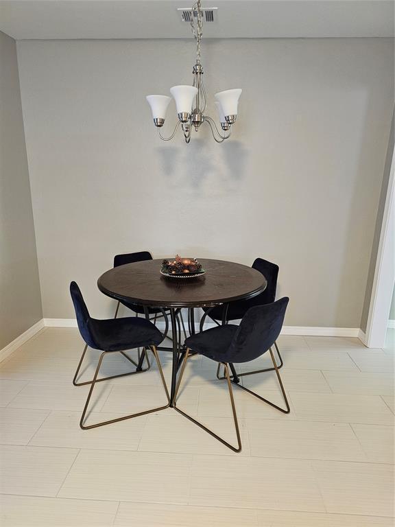 tiled dining room featuring a chandelier