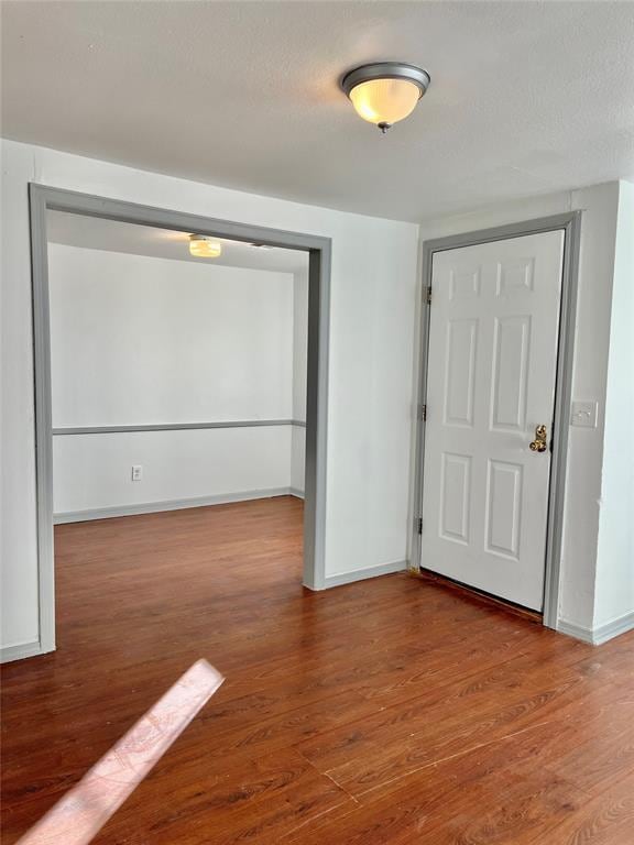 spare room featuring wood-type flooring and a textured ceiling