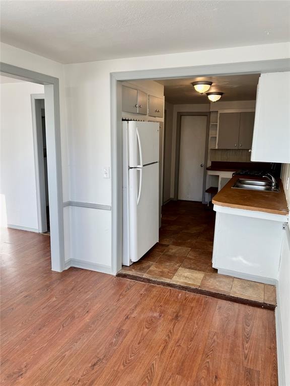 kitchen with sink, dark hardwood / wood-style flooring, and white refrigerator