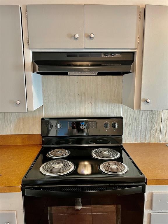 kitchen featuring black / electric stove and exhaust hood