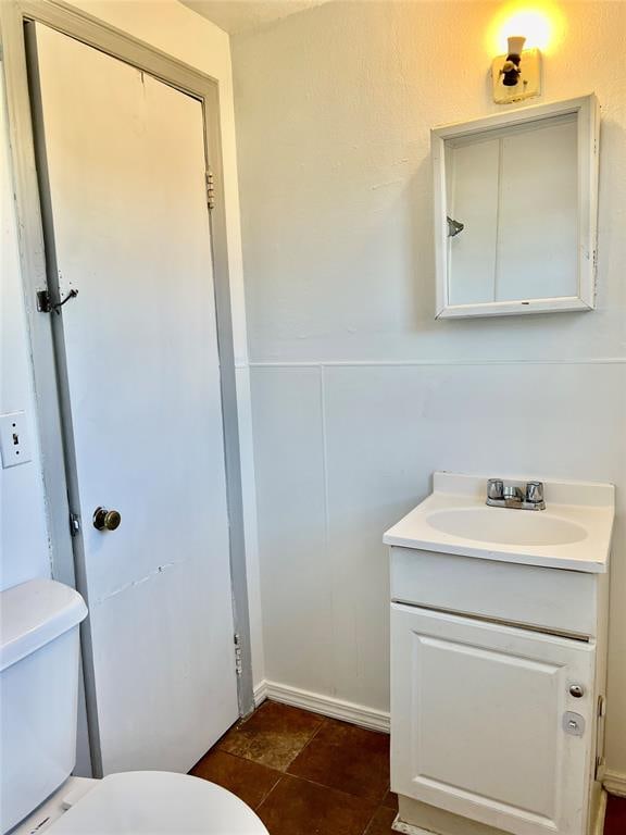 bathroom with tile patterned flooring, vanity, and toilet