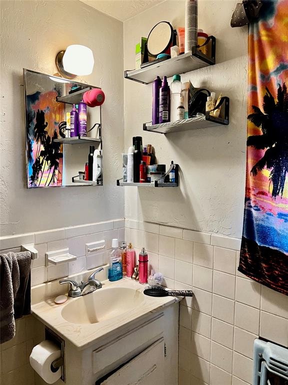 bathroom featuring vanity and tile walls