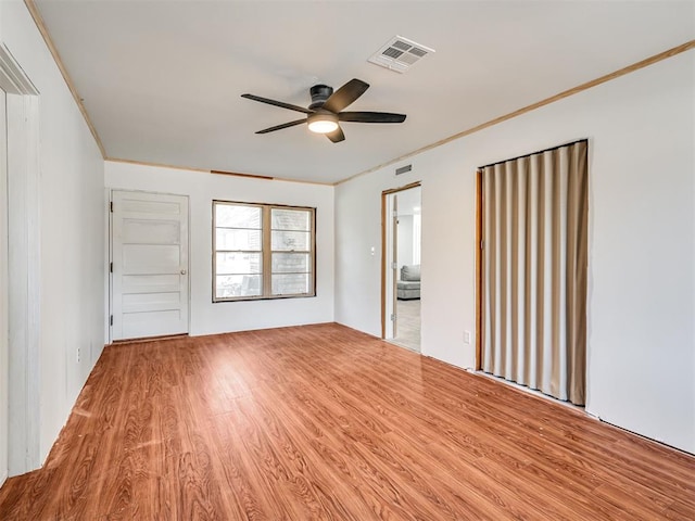 interior space with ceiling fan, ornamental molding, and hardwood / wood-style flooring