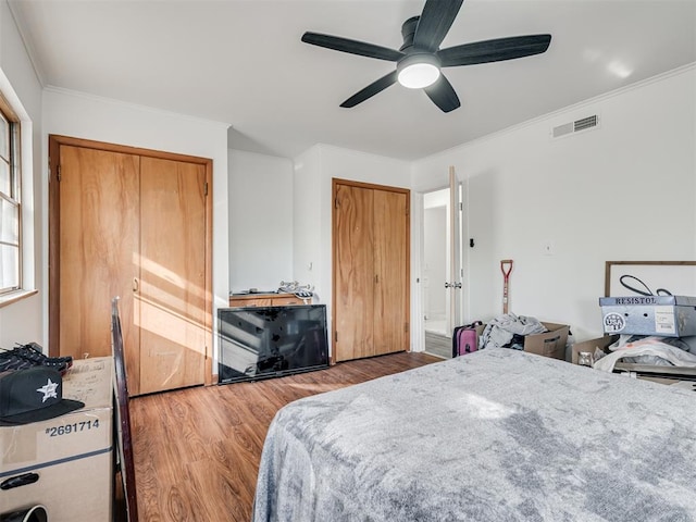 bedroom featuring ceiling fan, hardwood / wood-style floors, and crown molding