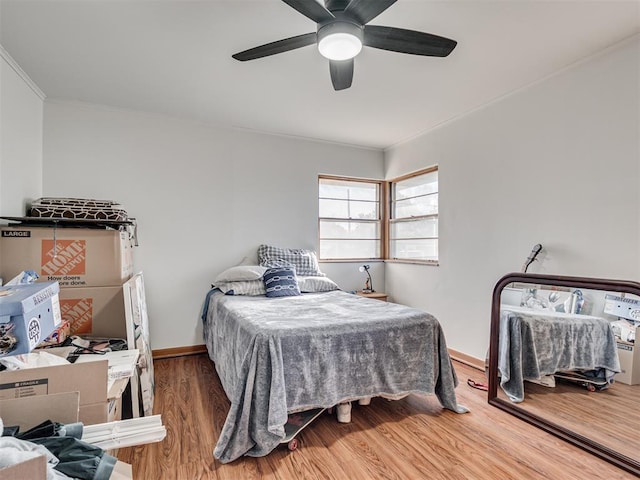 bedroom featuring hardwood / wood-style flooring, ceiling fan, and crown molding