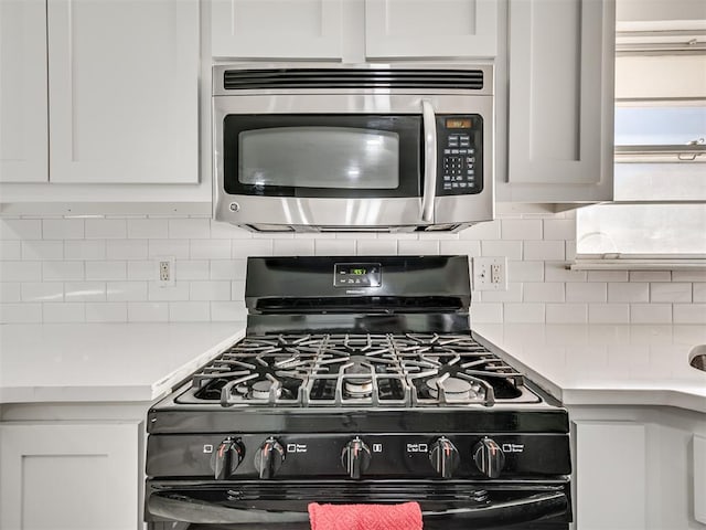 kitchen with tasteful backsplash, white cabinetry, and black range with gas cooktop