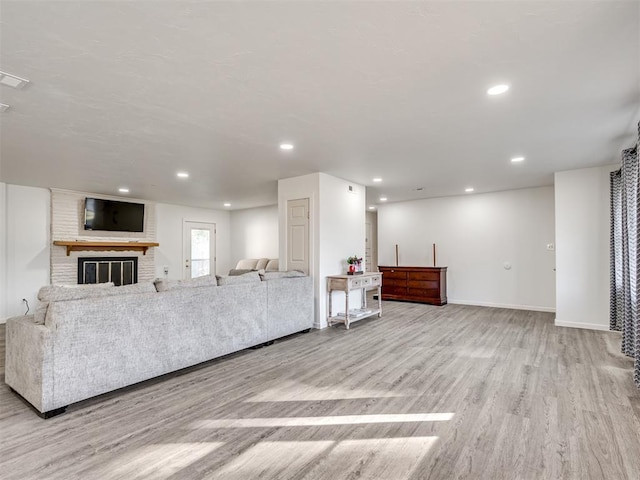 unfurnished living room with a fireplace and light hardwood / wood-style flooring