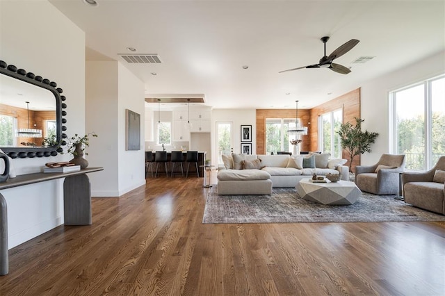 living room with dark hardwood / wood-style flooring, plenty of natural light, and ceiling fan