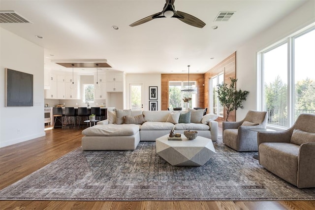 living room with dark hardwood / wood-style floors and ceiling fan