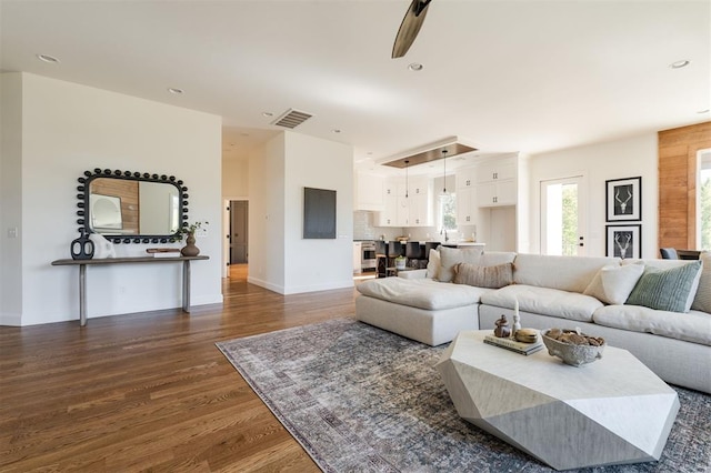 living room with dark hardwood / wood-style floors and ceiling fan