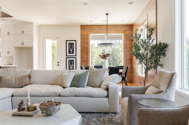 living room featuring wood-type flooring, a wealth of natural light, and wooden walls