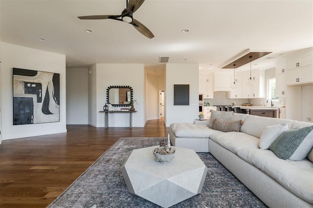 living room with ceiling fan, dark wood-type flooring, and sink