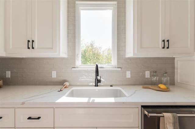 kitchen with white cabinetry, light stone countertops, dishwasher, sink, and backsplash