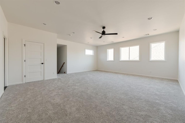 carpeted empty room featuring a wealth of natural light and ceiling fan