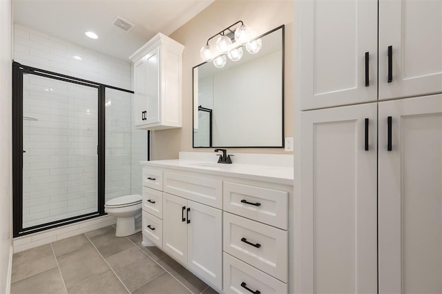 bathroom featuring tile patterned floors, walk in shower, vanity, and toilet