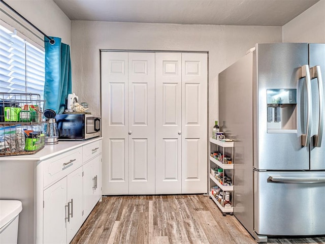 kitchen featuring white cabinets, light hardwood / wood-style floors, and appliances with stainless steel finishes