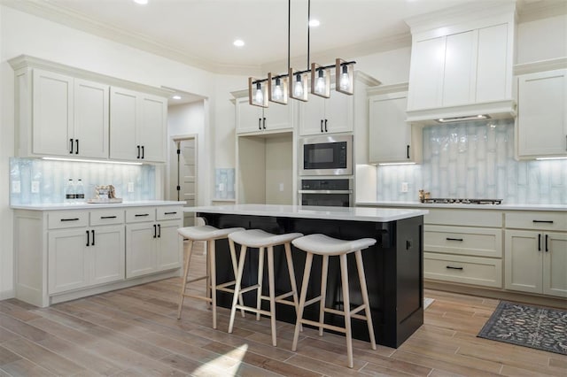 kitchen with a center island, light hardwood / wood-style floors, appliances with stainless steel finishes, and tasteful backsplash