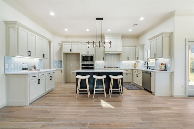 kitchen featuring light wood-type flooring, a center island, stainless steel appliances, and hanging light fixtures