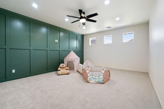 rec room featuring light carpet and ceiling fan