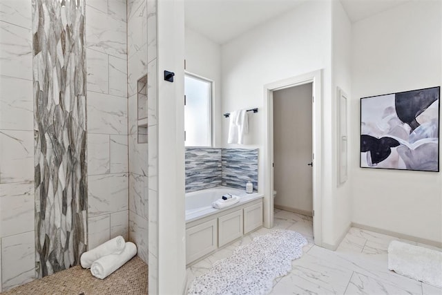 full bath with marble finish floor, a garden tub, baseboards, and toilet