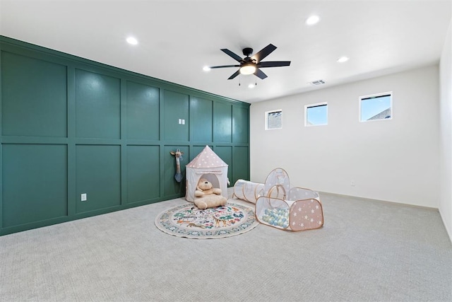 interior space featuring light carpet, visible vents, ceiling fan, a decorative wall, and recessed lighting