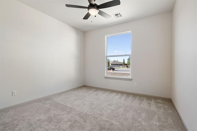 unfurnished room featuring baseboards, a ceiling fan, visible vents, and light colored carpet