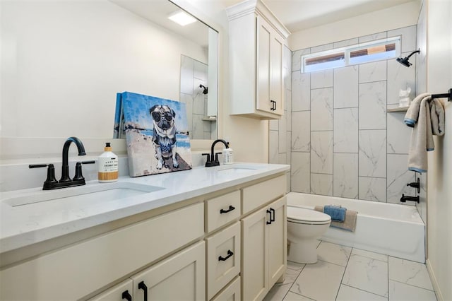 bathroom featuring marble finish floor, double vanity, a sink, and toilet